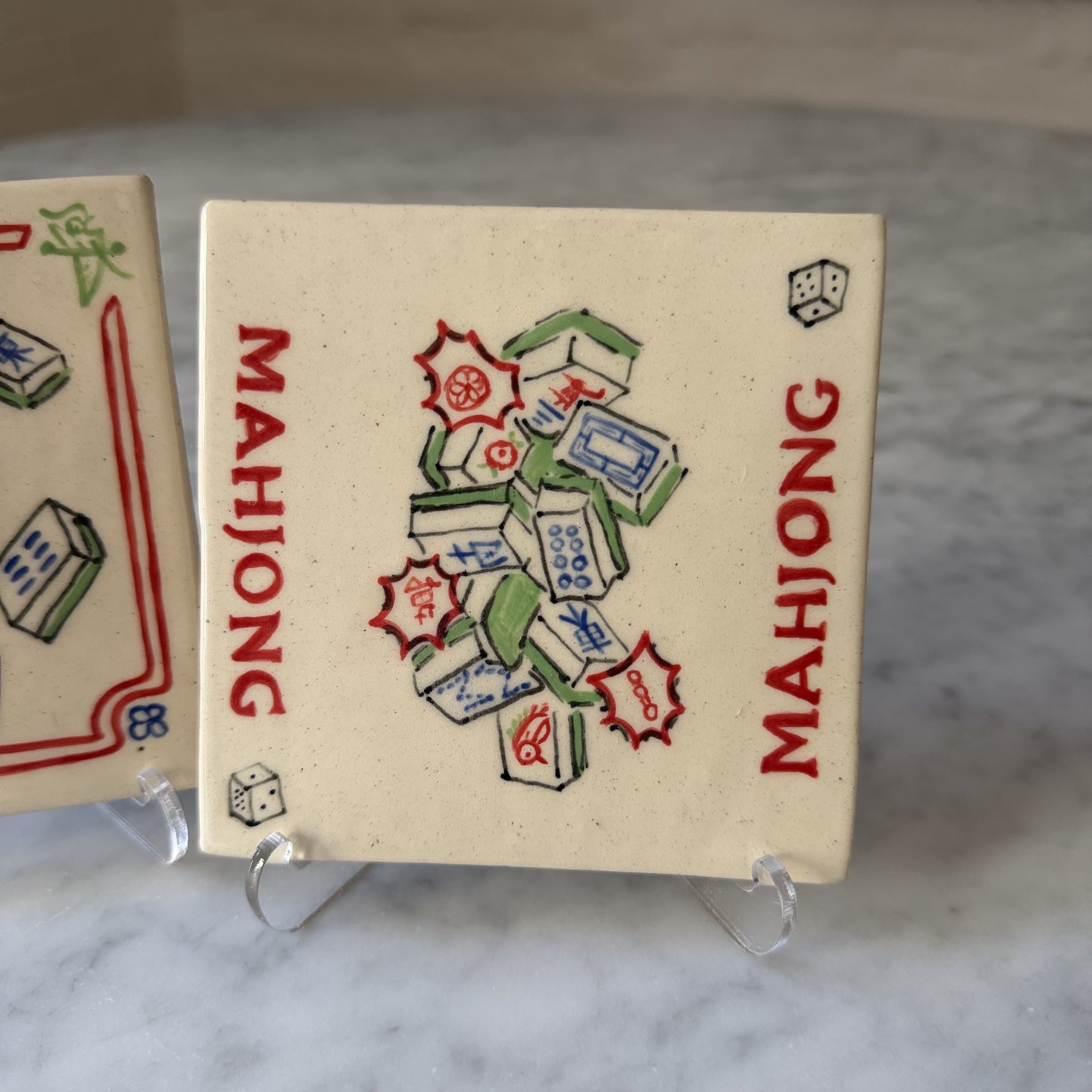 A hand-painted tile of mahjong tiles tumbling together, the word MAHJONG in red on two sides.
