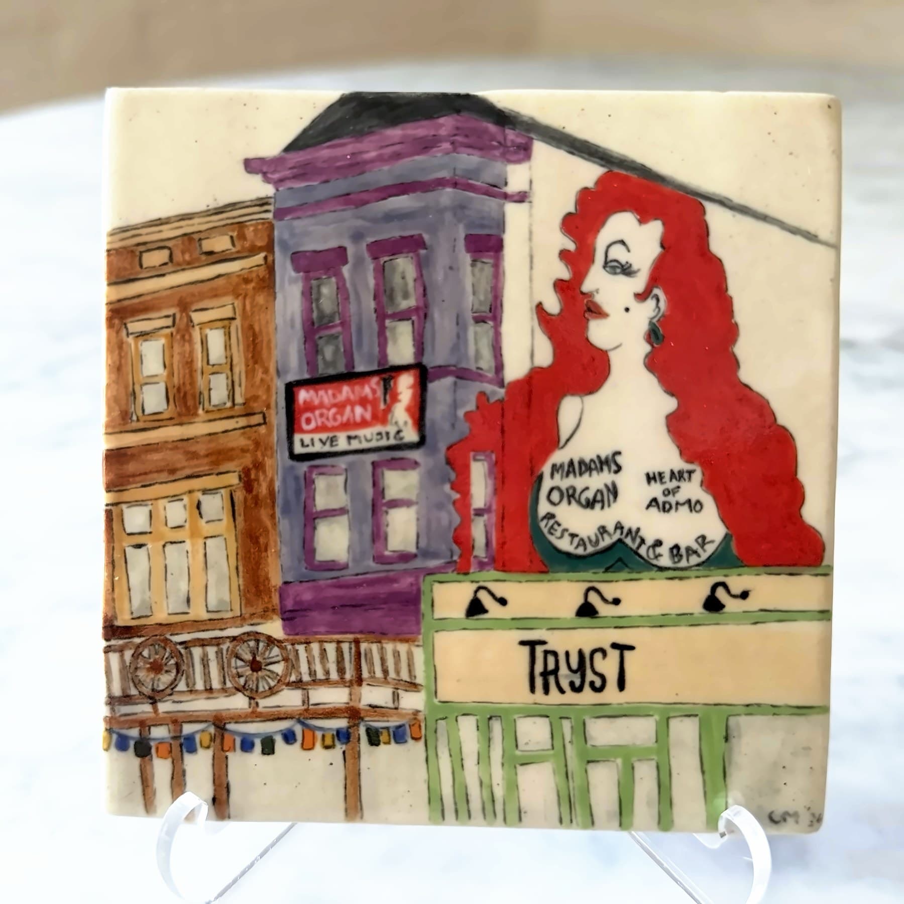 A tile painted with an Adams Morgan street scene: rowhouses, the Madam's Organ mural and the Tryst storefront.